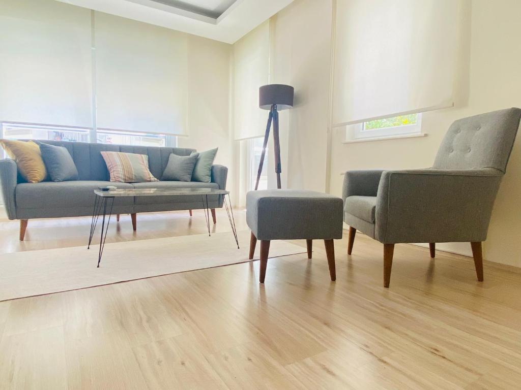 een woonkamer met een bank en twee stoelen bij Aether Flats No3,Old Town,Beach,Central,Netflix in Antalya