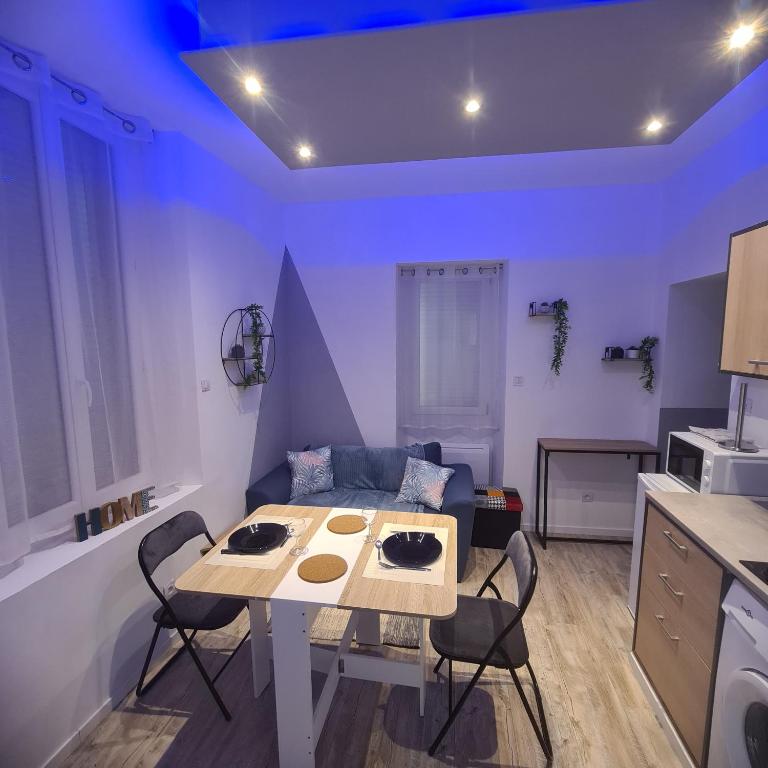 een keuken met een tafel en stoelen in een kamer bij Très joli appartement 2 pièces, centre-ville in Tuchan