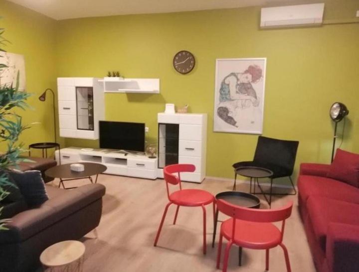 uma sala de estar com um sofá e cadeiras e uma televisão em Apartman Sara em Umag