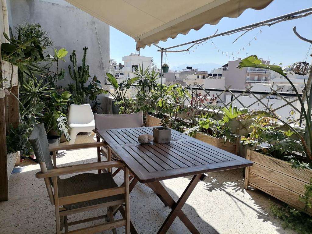 a table and chairs on a balcony with plants at Central Jungle Balcony Suite in Heraklio Town