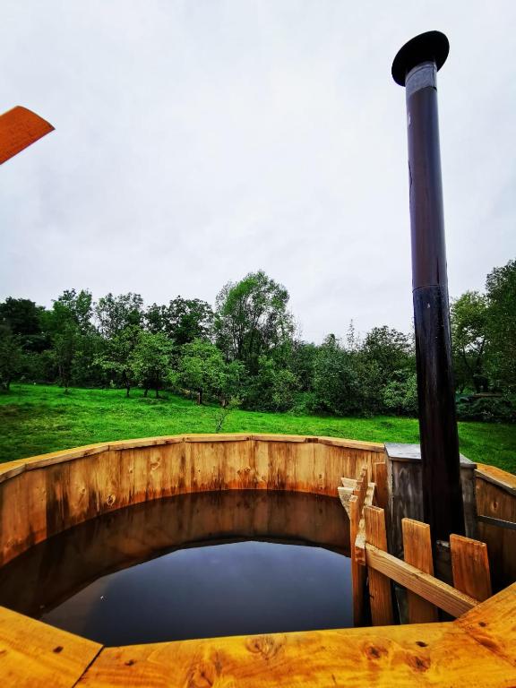 a pool of water in a wooden table with a pole at Casa Rusu in Mălăeşti