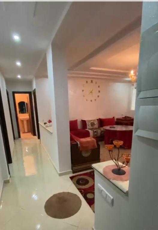 a living room with a couch and a clock on the wall at اقامة السعادة in Nador