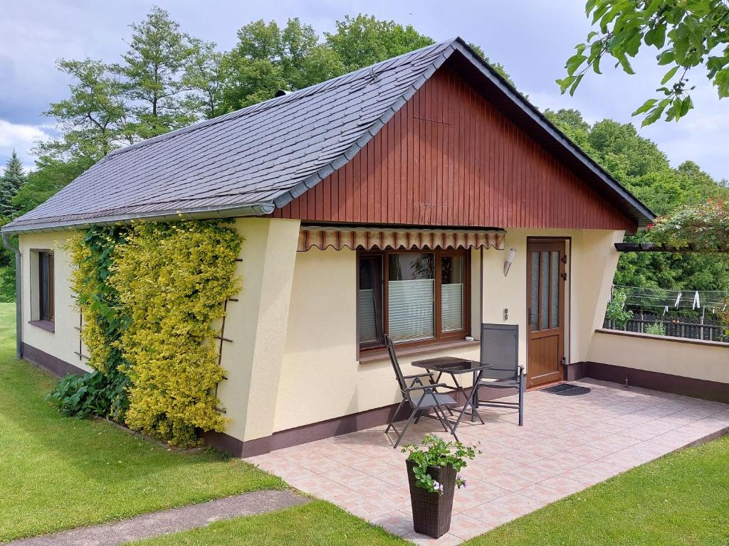 ein kleines Cottage mit einem Tisch und Stühlen in der Unterkunft Ferienhaus Willkommen in Bad Schandau