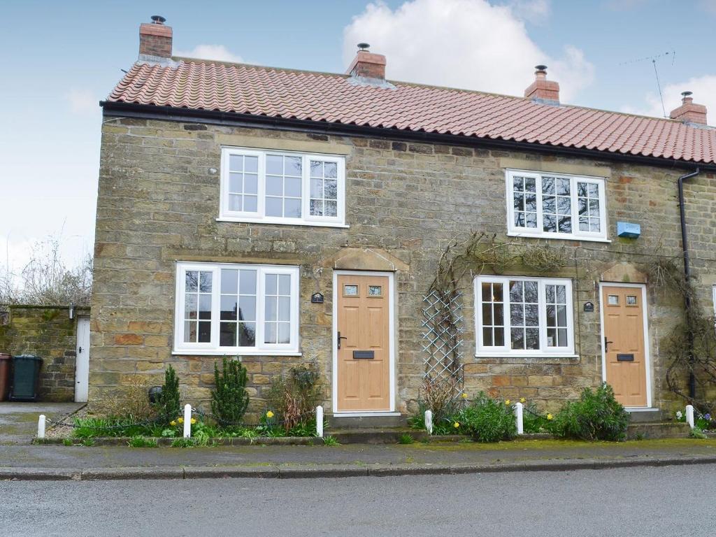 a brick house with white windows and brown doors at Keldholme Cottage 1 - Uk10992 in Kirkbymoorside