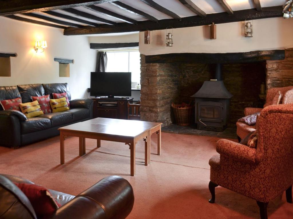 a living room with a couch and a table and a fireplace at Brambley Meadow- Uk11725 in Kentisbury