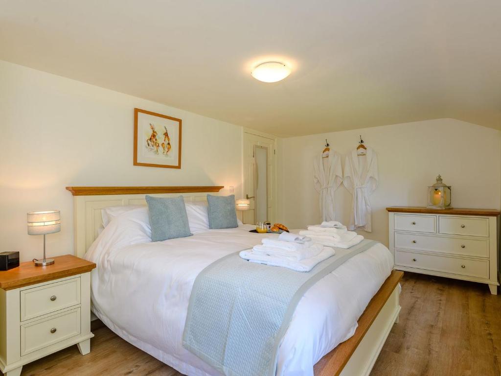 a bedroom with a white bed with towels on it at The Chicken Coop in Fulletby