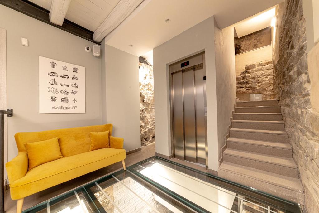 a yellow couch in a hallway with a glass floor at Mura 5&7 in Trieste