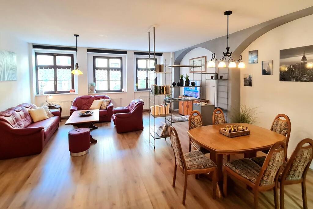 een woonkamer met een tafel en een bank bij NEU: Großzügige Citywohnung mit XXL Dachterrasse! in Freiberg