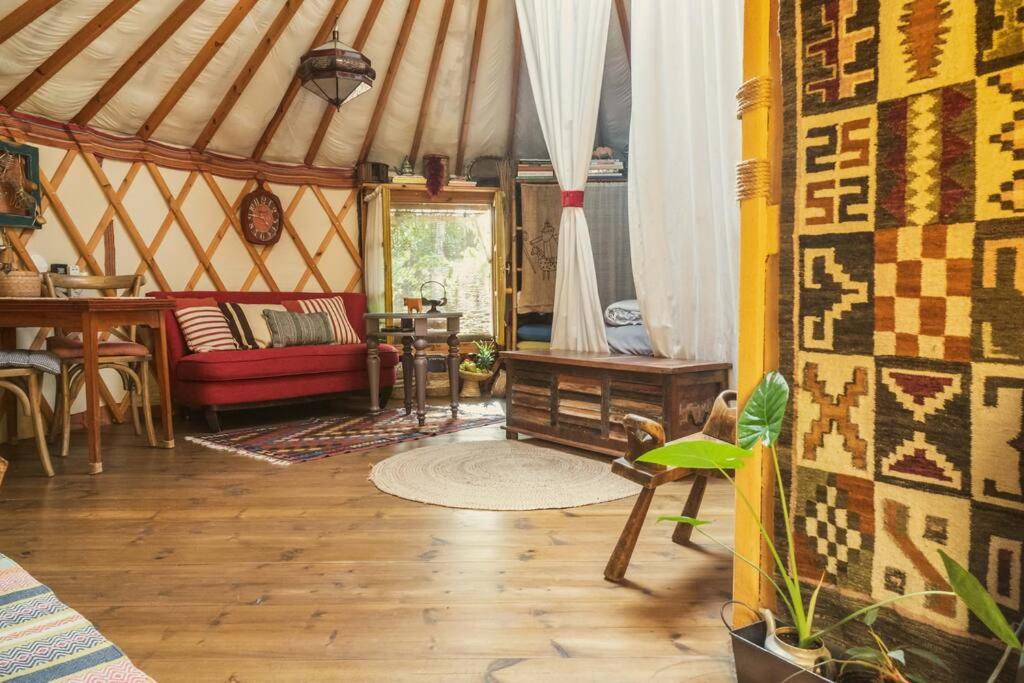 yurta con sofá rojo y mesa en The Yurt in Abirim, en Abirim