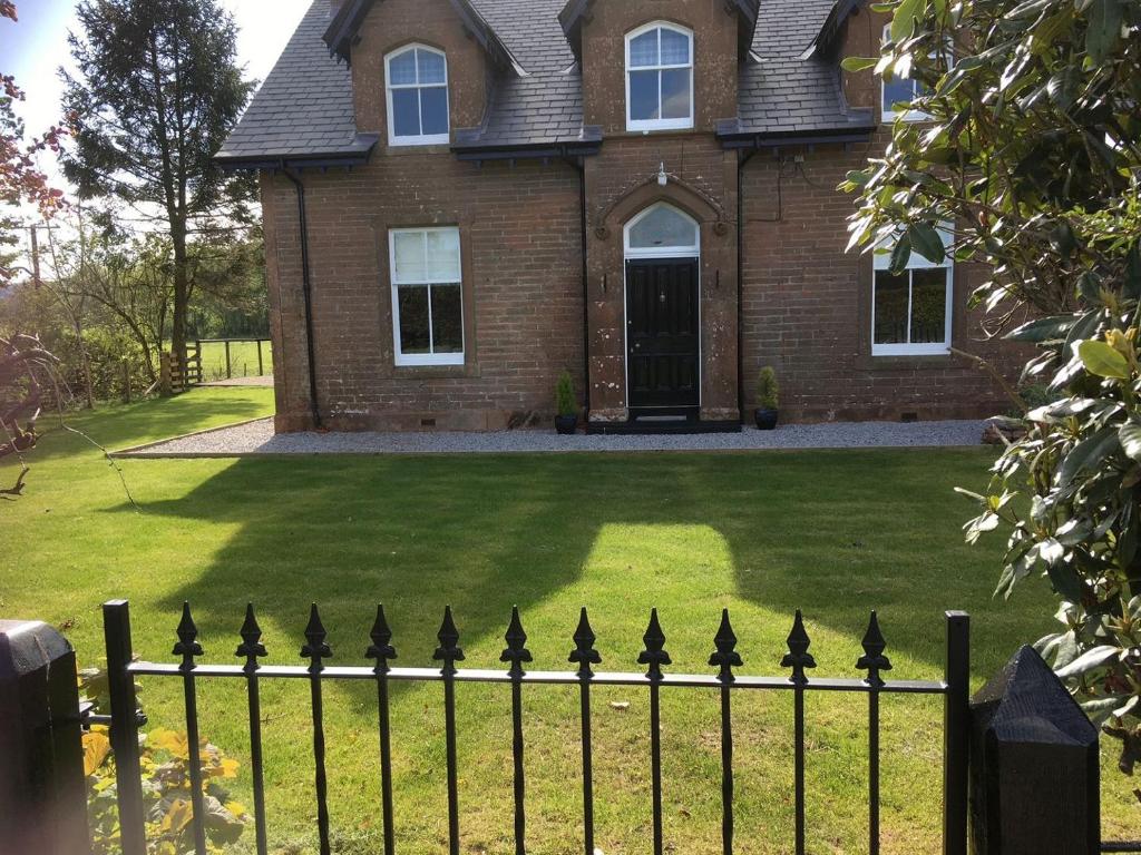 a black fence in front of a house at Halleaths Home Farm in Lochmaben