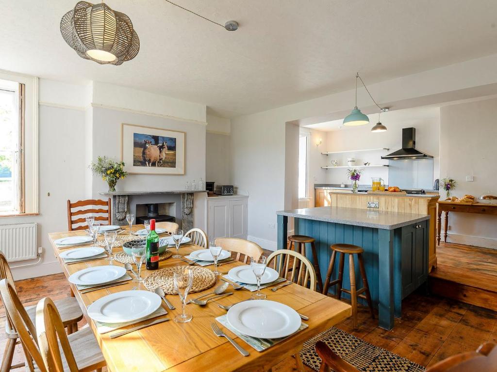 een eetkamer met een houten tafel en een keuken bij Colveston Manor in Cranwich