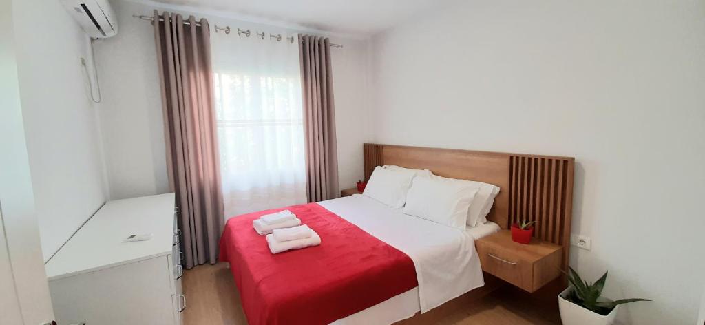 um quarto com uma cama com duas toalhas em Comfy apartment- Sunny balcony em Tirana