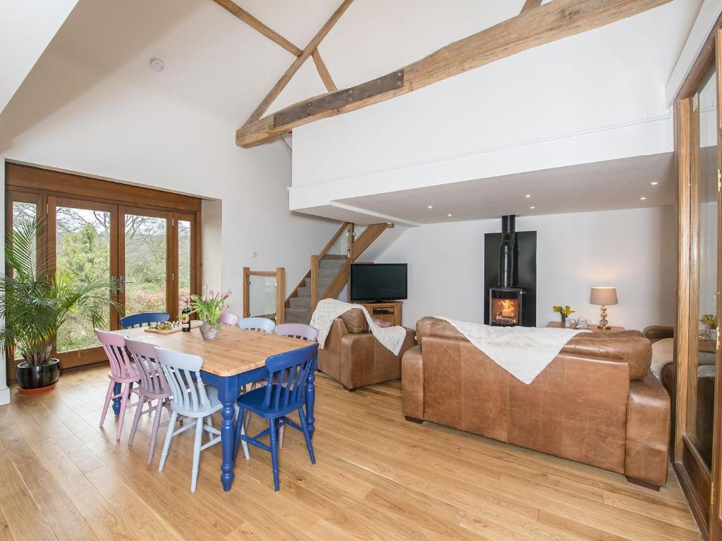a living room with a table and chairs and a couch at Harewood Barn in Brompton Regis