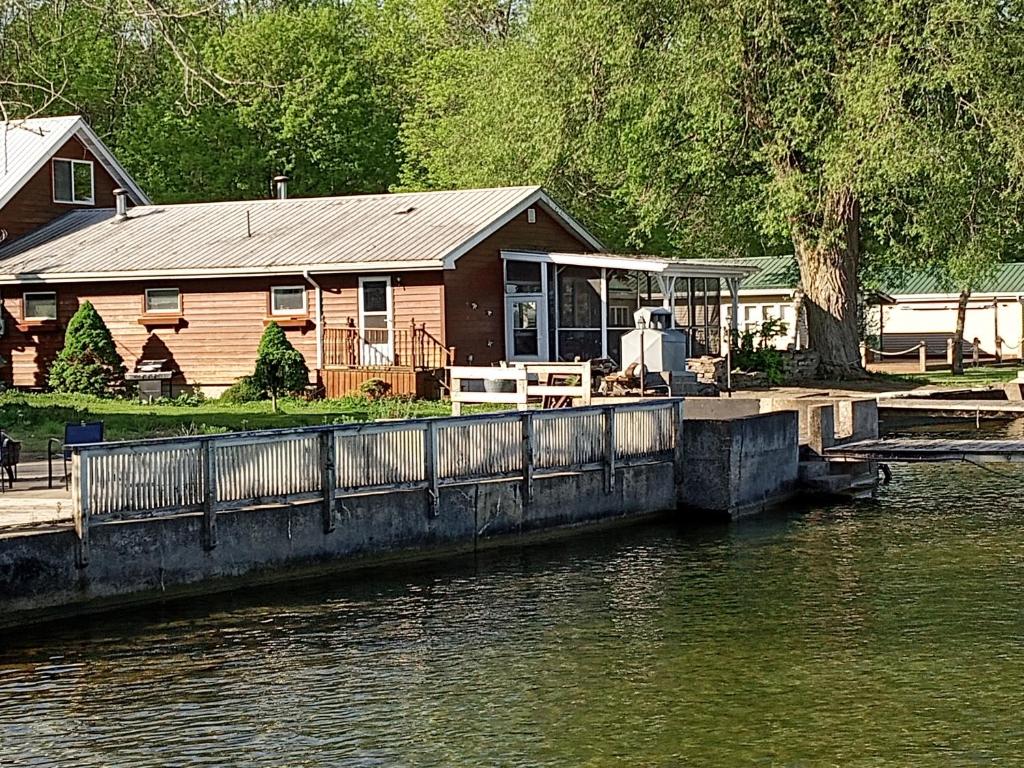 a house with a dock next to a body of water at 2,000 ft home on the St Lawrence, incredible views Canada, hot tub in Ogdensburg