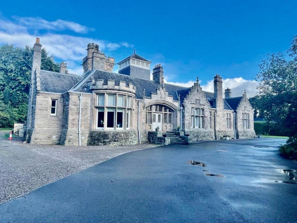 an old stone house with a driveway in front of it at Serviced Accommodation Moray - Lesmurdie House No 2 in Elgin