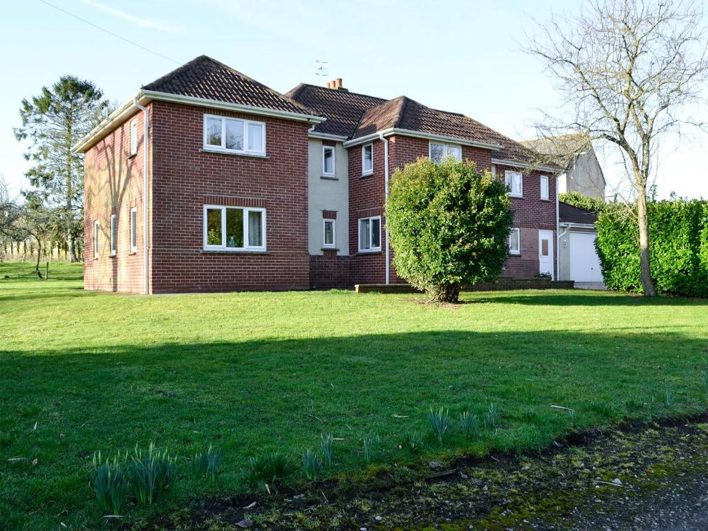 a large brick house with a grass yard at Copper Beech in Netherbury