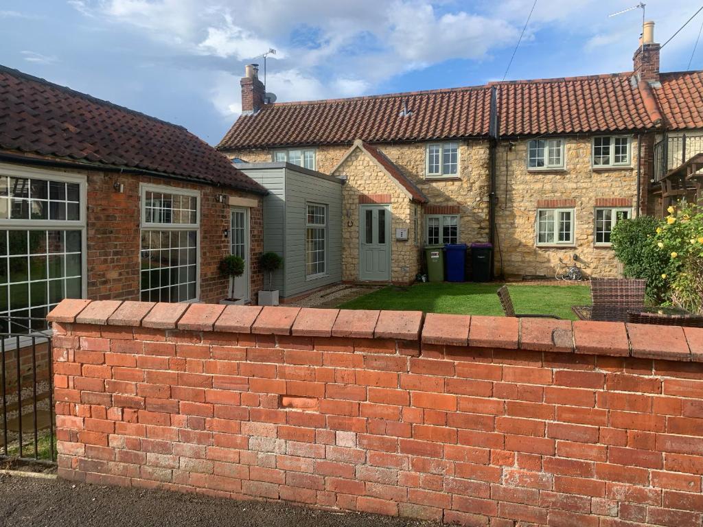 a brick wall in front of a house at Farriers Cottage in Lincoln