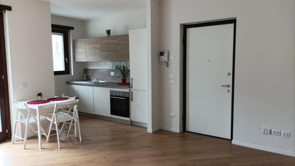 uma cozinha com uma mesa e cadeiras e uma porta em Apartment Milano Via Roncaglia em Milão