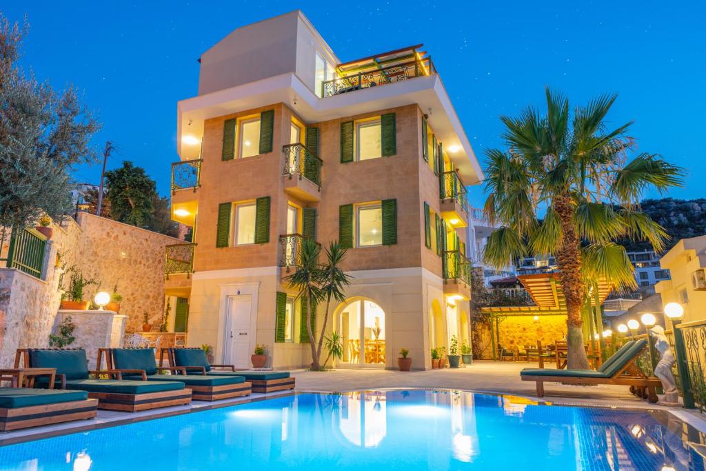 une grande maison avec une piscine devant dans l'établissement Villa Grande Kalkan, à Kaş