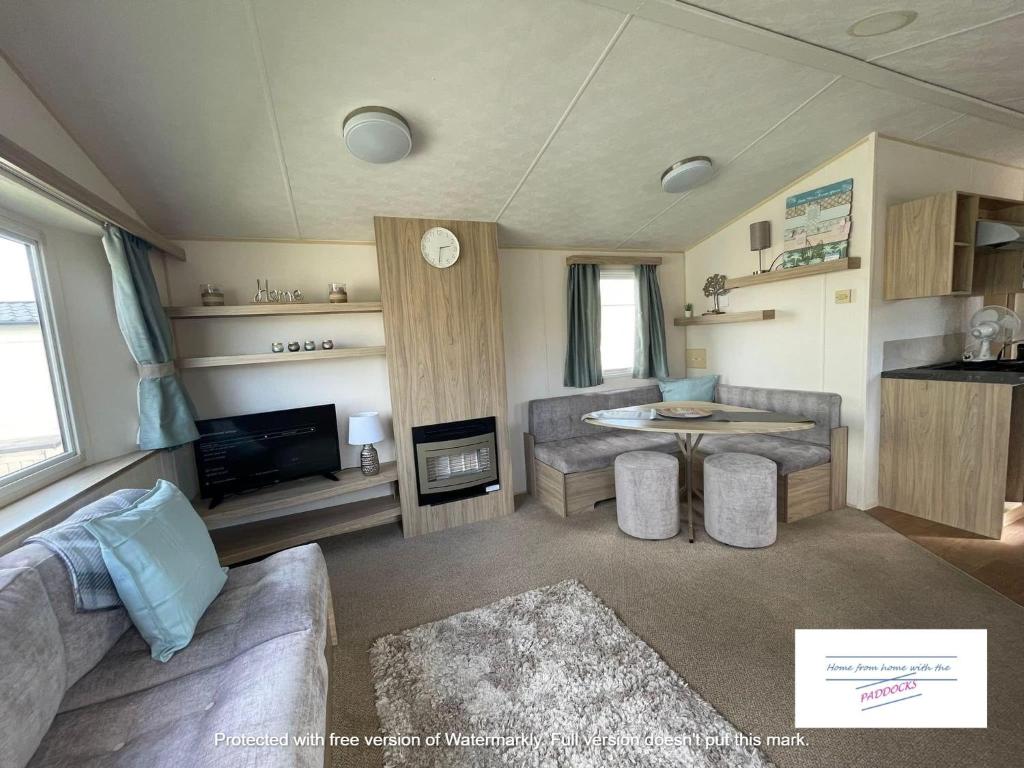 a living room with a couch and a table at Robin hood Caravan park North Wales Free Wi-Fi and Smart TVs Passes not included in Rhyl