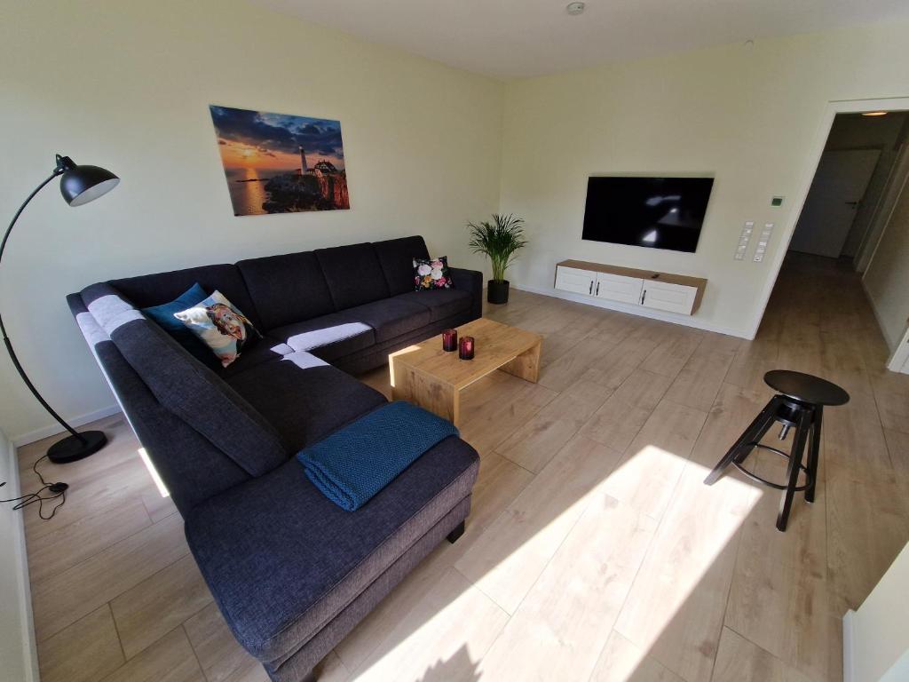 sala de estar con sofá y TV en Apartment nahe Meyer Werft in Ostfriesland mit Küche & Netflix, en Westoverledingen