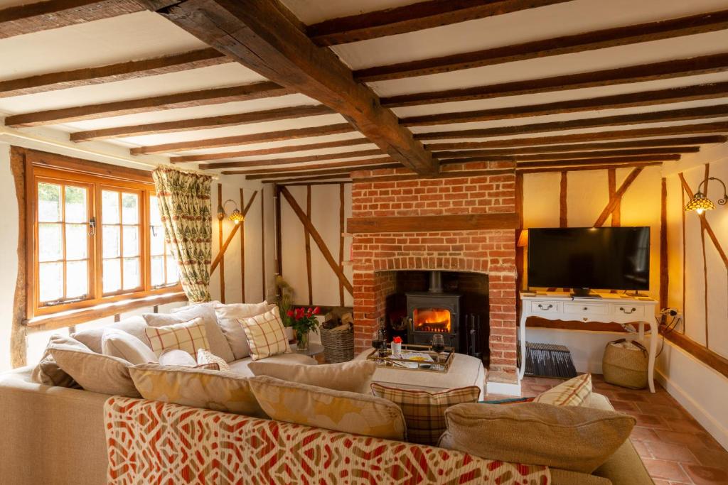 a living room with a couch and a fireplace at Vine Cottage 