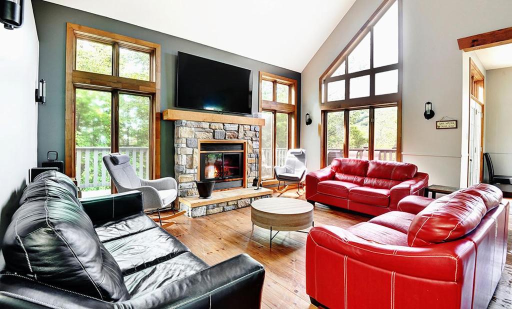 a living room with red furniture and a fireplace at Chalets Alpins -41 Chemin des Skieurs in Stoneham
