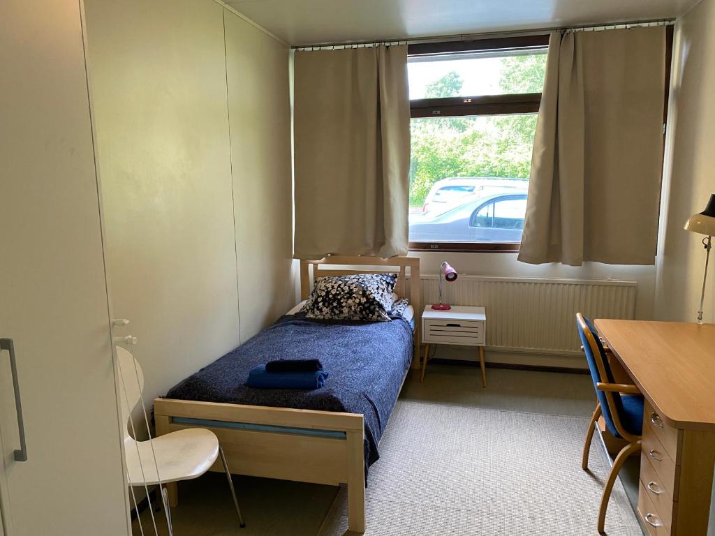 a small bedroom with a bed and a window at Kokemäen opisto in Kokemäki