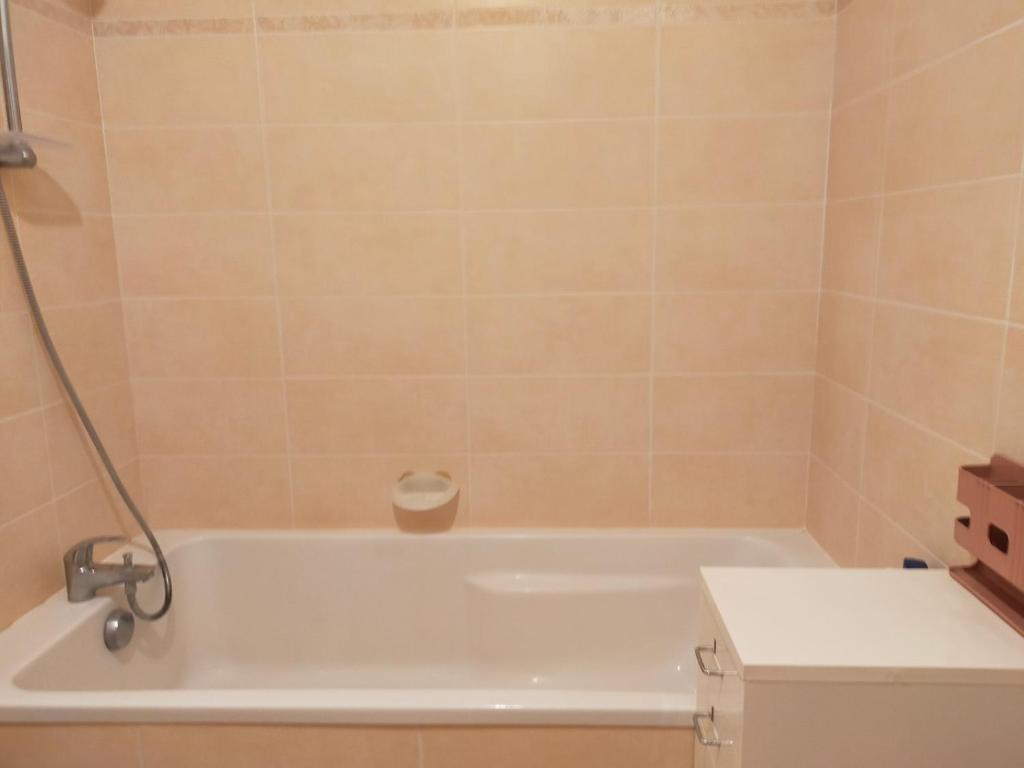 a bathroom with a white bath tub with a toilet at a nice room in Annemasse