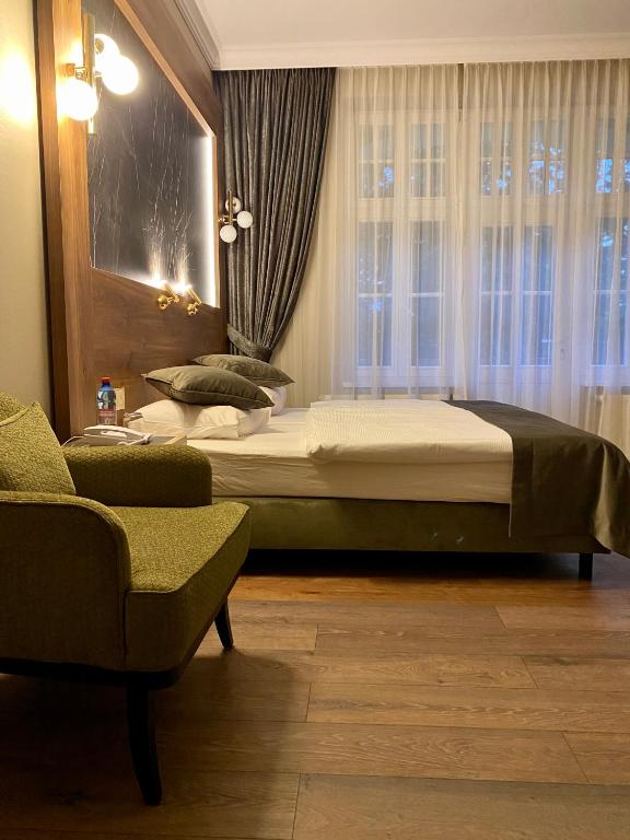 sypialnia z łóżkiem, krzesłem i oknem w obiekcie Pensjonat - Restauracja Żółty Domek w Szczecinku