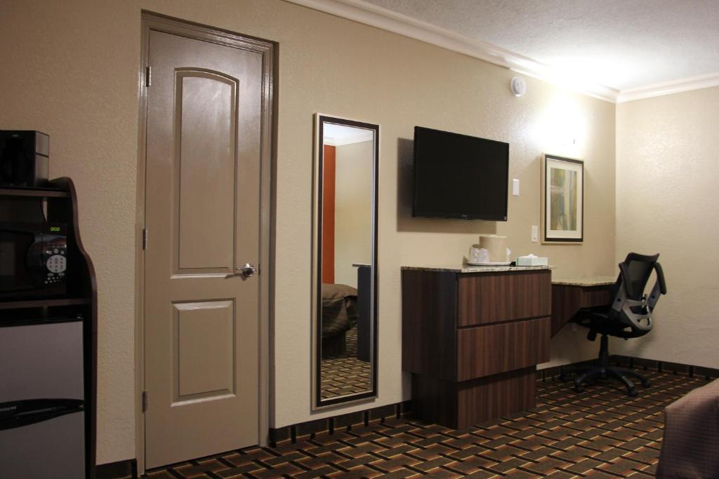 a hotel room with a door and a mirror at Budget Inn Lake Wales in Lake Wales