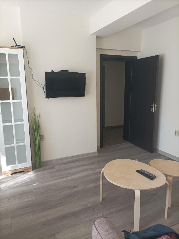 sala de estar con 2 mesas y TV de pantalla plana en Apartment Starfish, en Varna