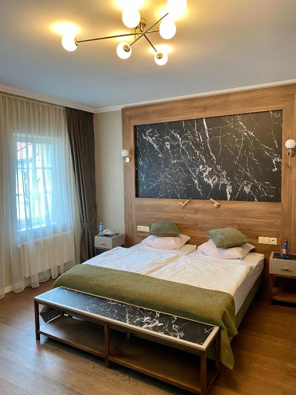 sypialnia z dużym łóżkiem i dużą ścianą w obiekcie Pensjonat - Restauracja Żółty Domek w Szczecinku