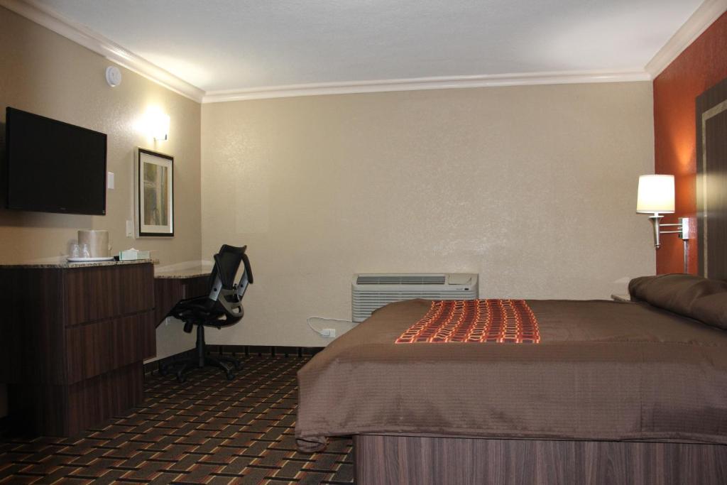 a hotel room with a bed and a desk at Budget Inn Lake Wales in Lake Wales