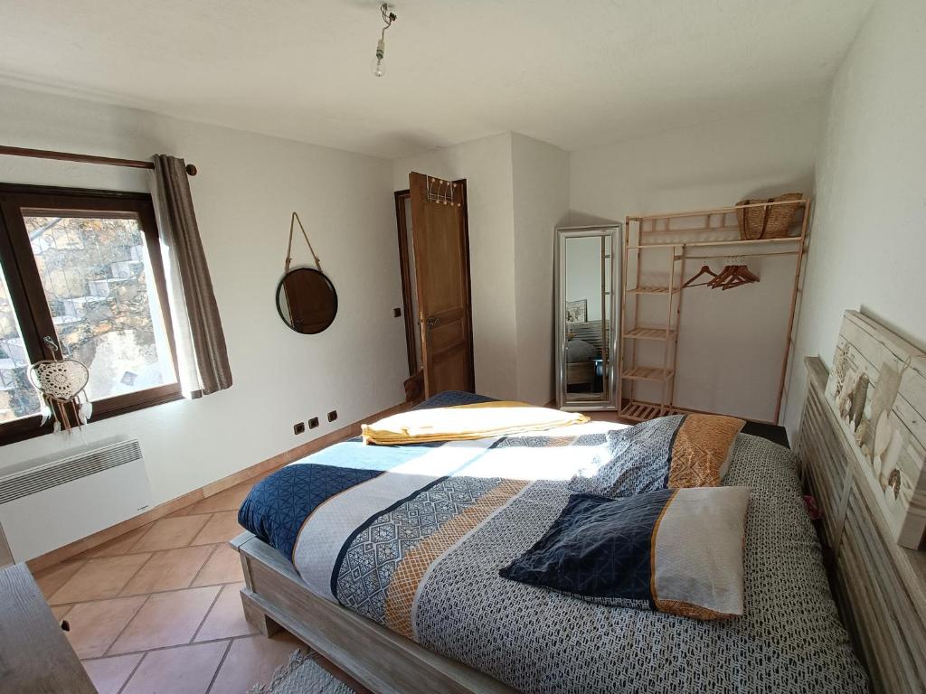 Schlafzimmer mit einem Bett und einem Fenster in der Unterkunft Appartement privatisé dans maison in Utelle