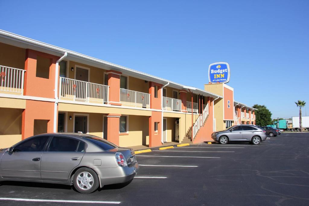 a car parked in a parking lot in front of a motel at Budget Inn Lake Wales in Lake Wales