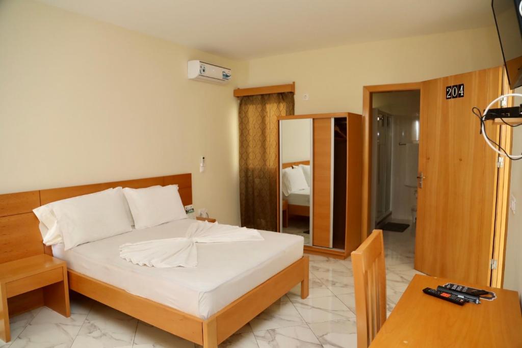 a bedroom with a bed and a table and a mirror at Cruzeiro Guest House in São Filipe