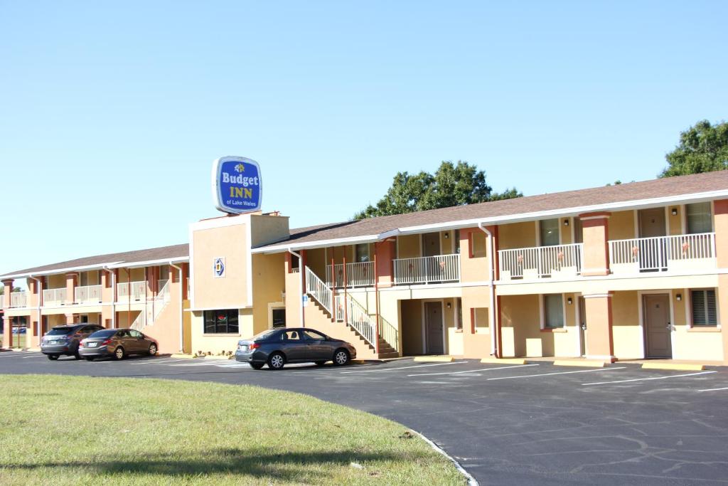 a hotel with cars parked in a parking lot at Budget Inn Lake Wales in Lake Wales