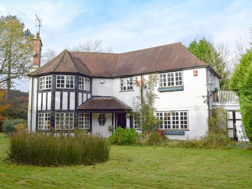 a white and black house with a yard at Springfields in Leek