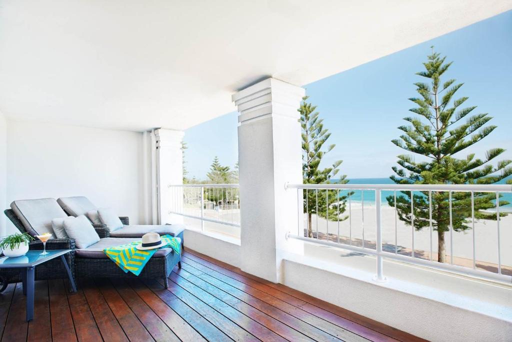 
a living room filled with furniture and a balcony at Cottesloe Beach Hotel in Perth
