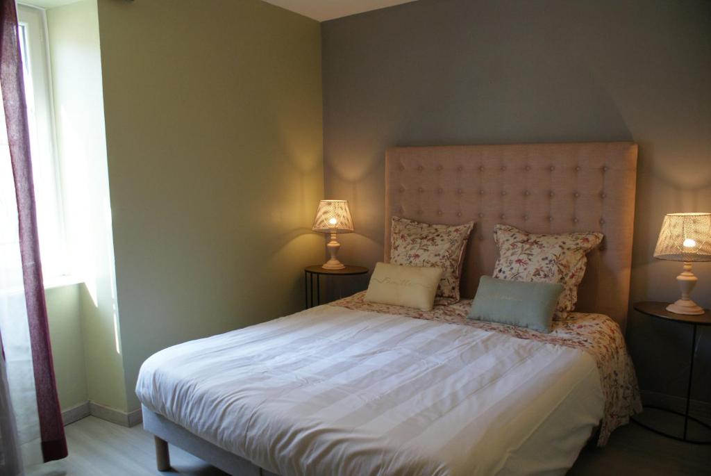 een slaapkamer met een groot bed met 2 lampen bij Escapade bourguignonne in Volnay