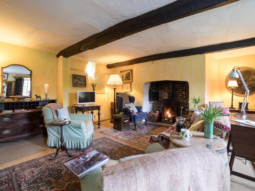 a living room with a couch and a fireplace at The Old Priory Cottage in Dunster