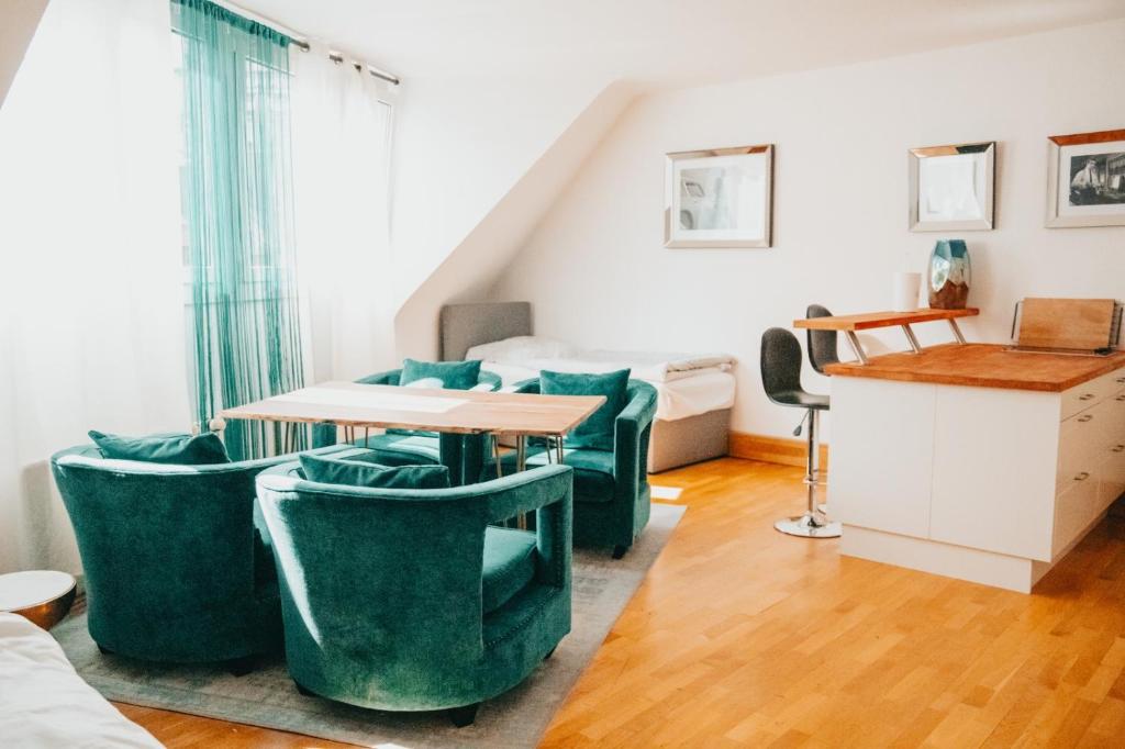 Cette chambre comprend une table et des chaises vertes. dans l'établissement Jalda Apartments, à Düsseldorf