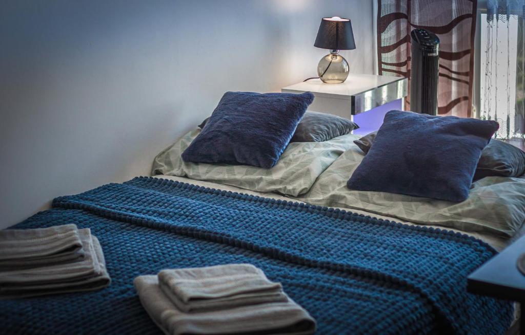 una cama con almohadas azules en una habitación en Komfortowy Apartament Seven niedaleko centrum, en Olsztyn