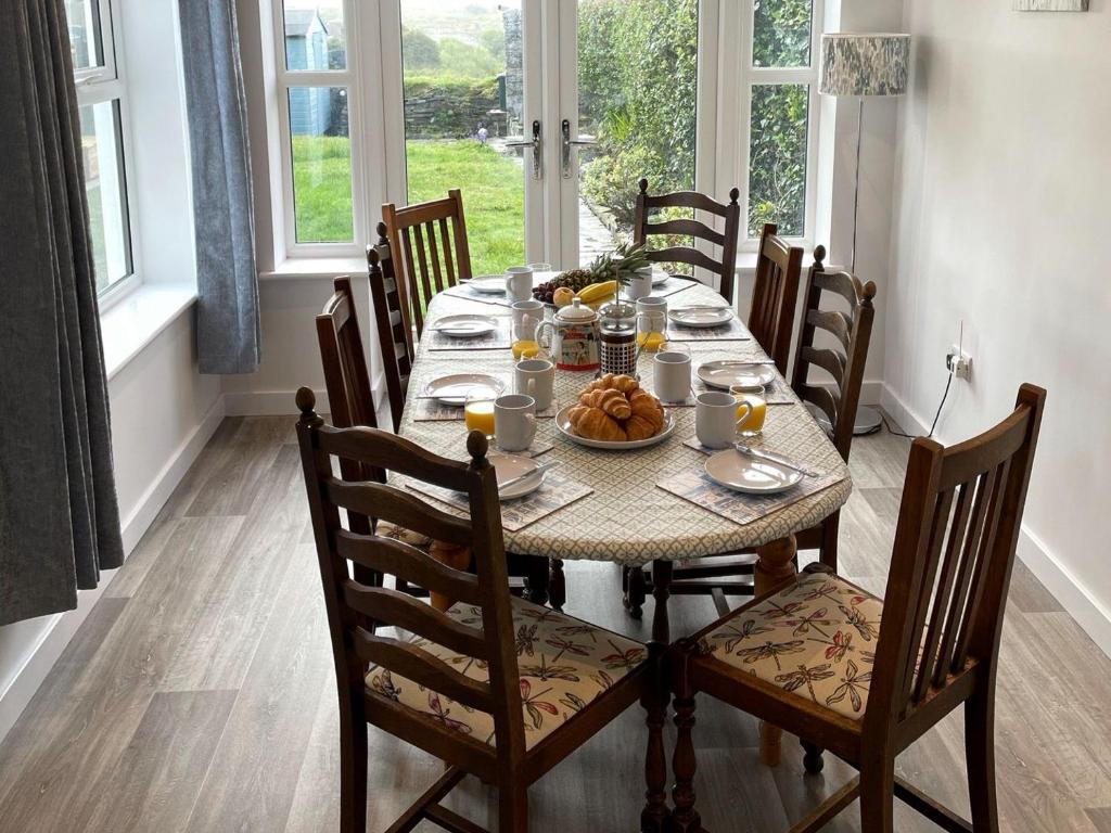 een eetkamer met een tafel met eten erop bij Moor View in Delabole