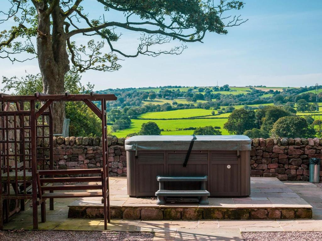 a hot tub and a bench next to a tree at Dairy House Farm in Horton