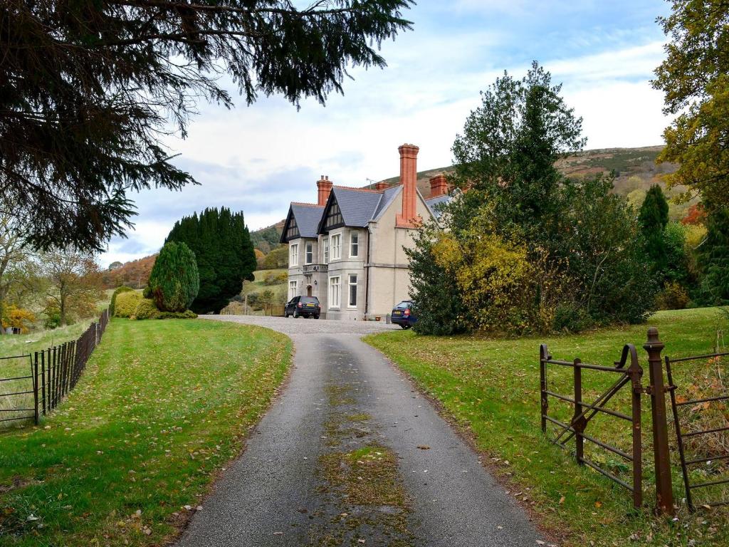 a house on a road with a fence at The East Wing At Grove Hall in Bodfari