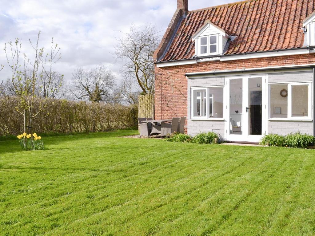 a house with a large lawn in front of it at Apple Tree Cottage in Foulsham