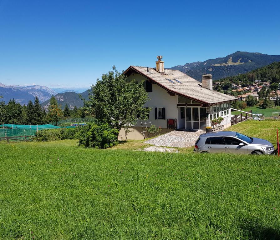 a house with a car parked in a field at Chalet Heidi in Serrada