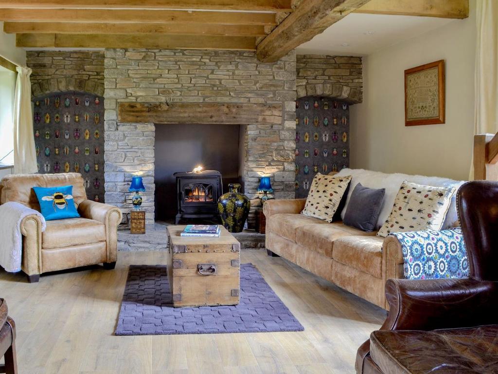 a living room with a couch and a fireplace at The Old Cider Mill in Llanstephan